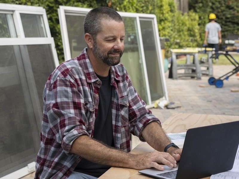 Um homem usando o software QuickBooks em um laptop.