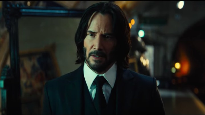 Keanu Reeves stares and walks into a scene from John Wick: Chapter 4. 