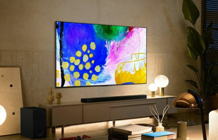 Смарт-телевизор LG B2 OLED 4K, прикрепленный к стене над развлекательным центром в гостиной.