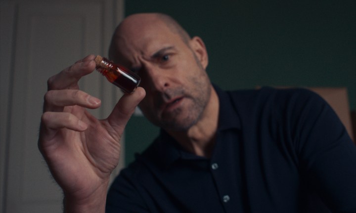 Mark Strong segura um frasco de sangue em uma cena de Nocebo.