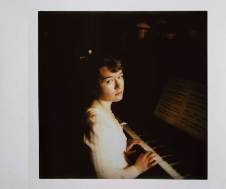 Foto instax di una donna che suona il pianoforte.