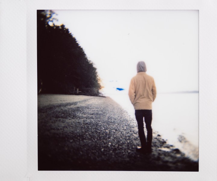 Foto instax di un uomo in piedi su una spiaggia.