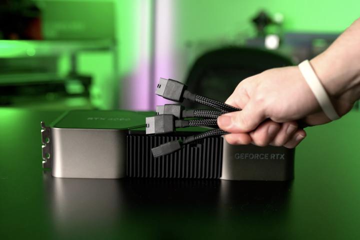 Nvidia GeForce RTX 4090 is shown along with a hand holding the power cable adapter.