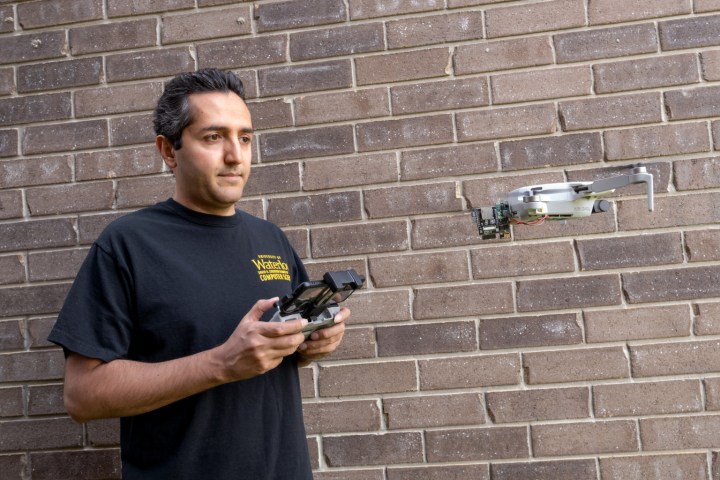 El profesor Ali Abedi volando Wi-Peep de pie contra la pared de ladrillos.