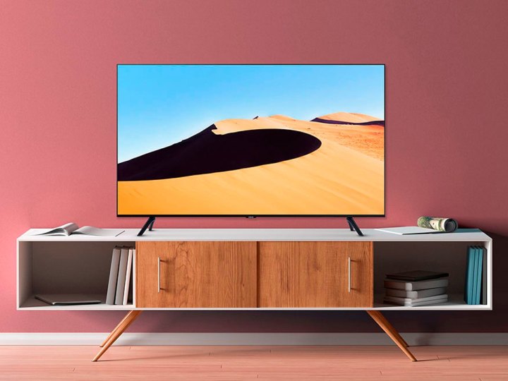 El Samsung TU69OT 4K Smart TV en un gabinete multimedia en una sala de estar.