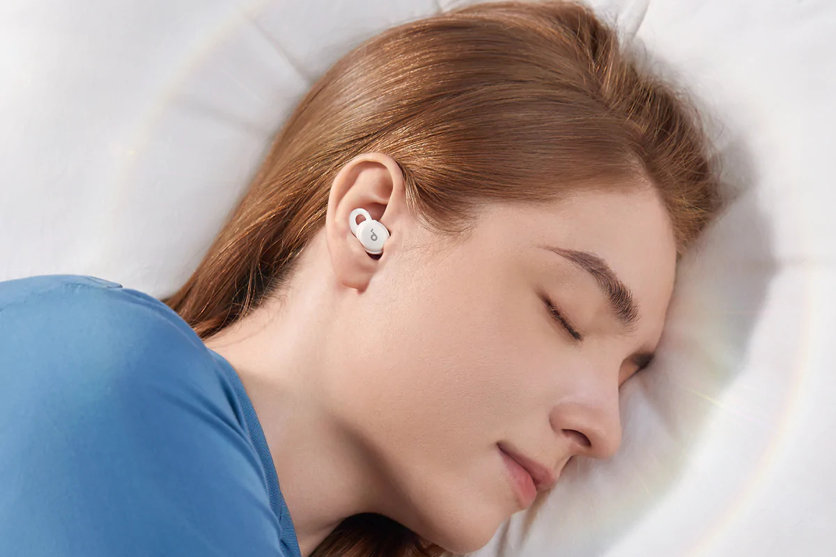 Mulher dormindo com os fones de ouvido Sleep A10.