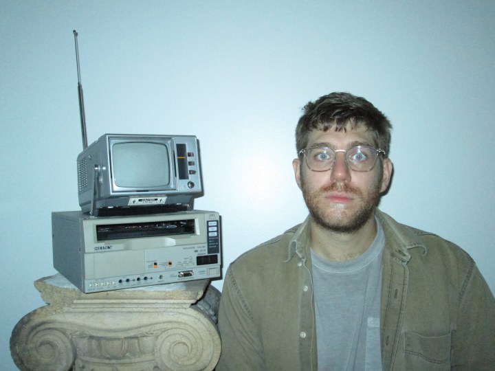 Alex Phillips pose devant une vieille télévision.