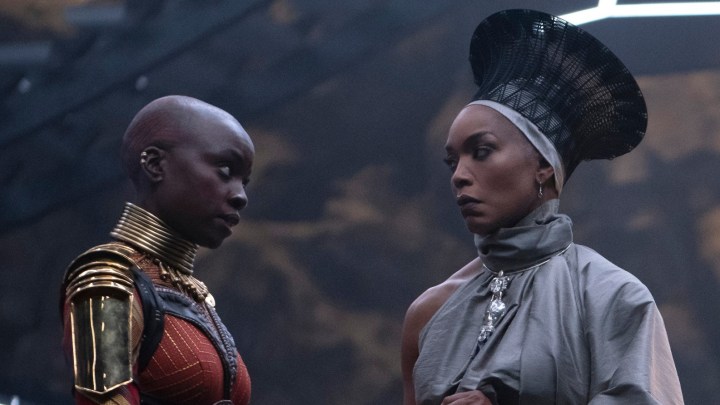 Danai Gurira and Angela Bassett stare intently at each other in a scene from Black Panther: Wakanda Forever.