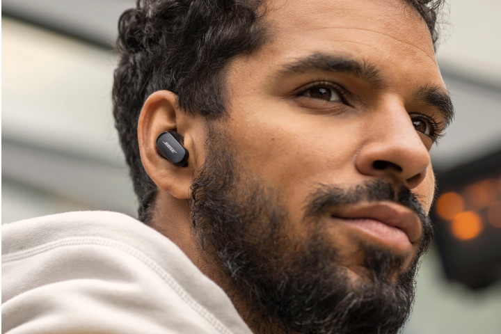 A man wear the Bose QuietComfort II earbuds.
