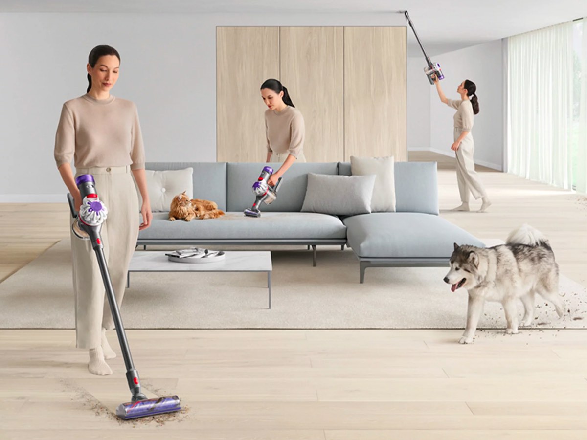 A woman uses the Dyson V8 cordless vacuum in multiple positions to clean her living room.
