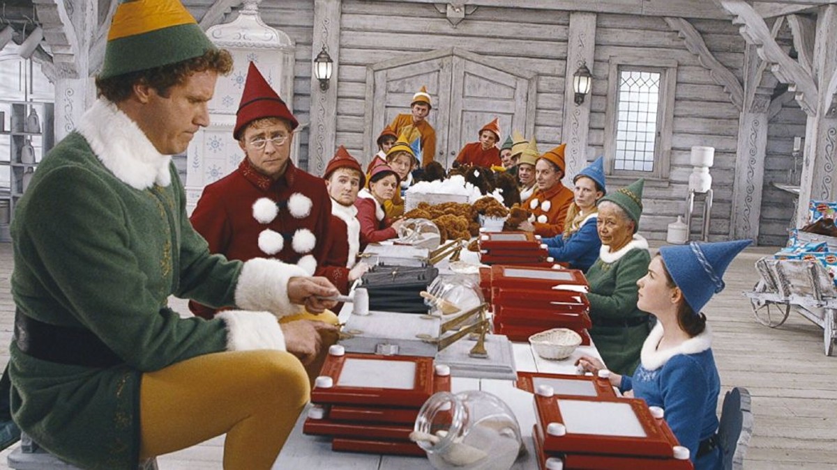 Buddy stands at a table with elves in Elf.