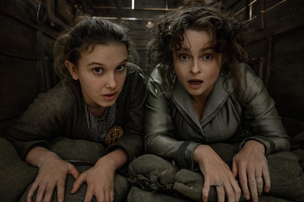 Millie Bobby Brown and Helena Bonham Carter hide under floorboards in a scene from Enola Holmes 2.
