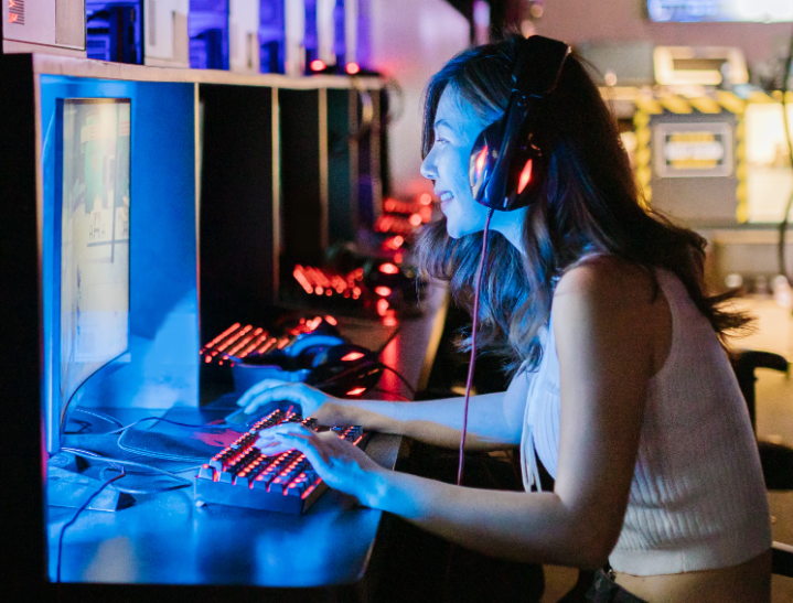 mujer joven jugando videojuegos en una pc