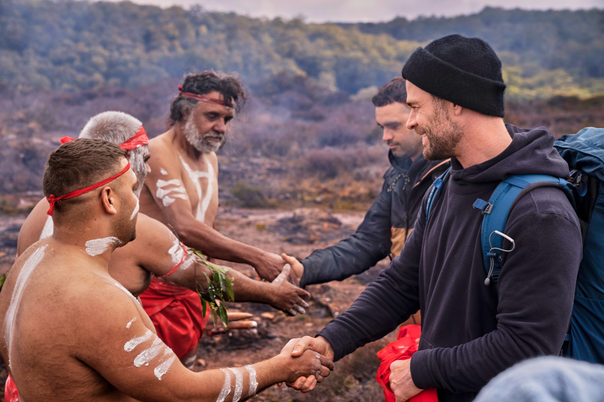 Chris Hemsworth spricht in einer Szene aus „Grenzenlos“ mit einer Gruppe von Ureinwohnern.