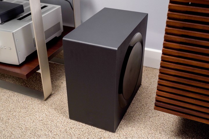 The Samsung Q990B's included subwoofer sits next to a large media stand