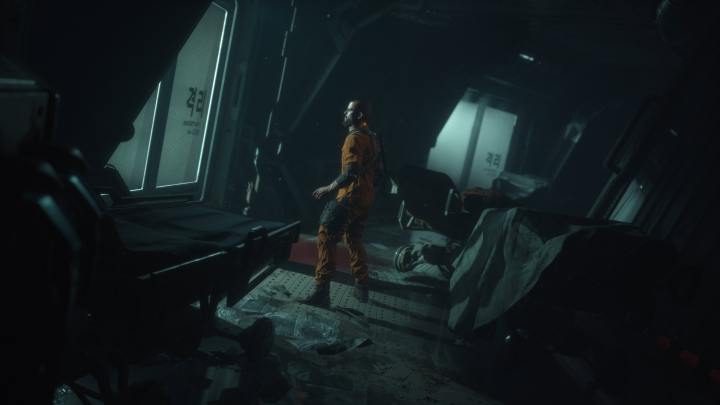 Jacob Lee stands in a dark hallway in The Callisto Protocol.