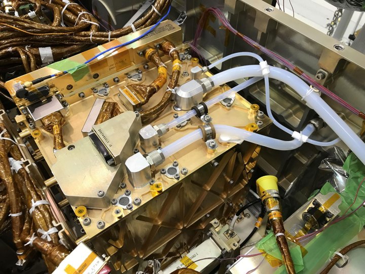 En esta imagen, el instrumento Mars Oxygen In-Situ Resource Utilization Experiment (MOXIE) chapado en oro brilla después de ser instalado dentro del rover Perseverance.