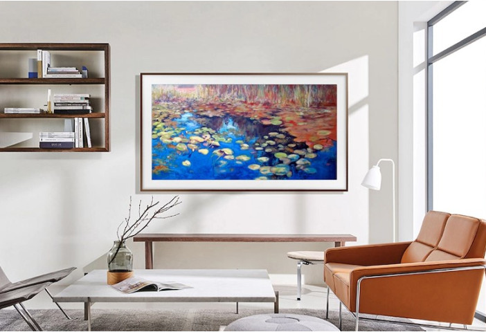 A TV Samsung Frame de 50 polegadas está pendurada na parede da sala exibindo arte.