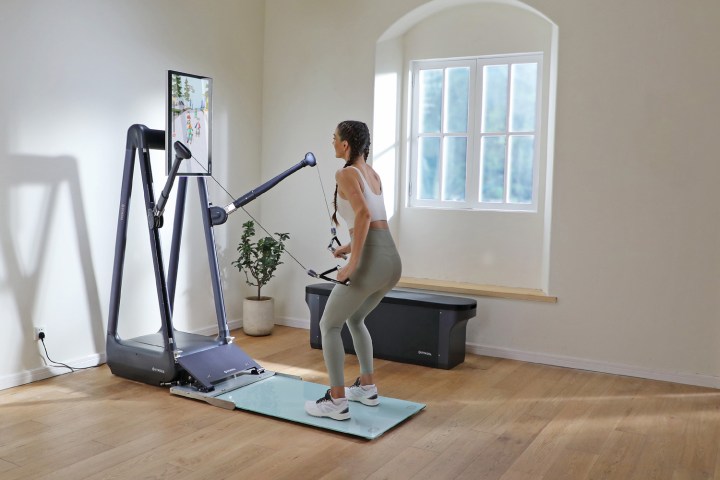 Una mujer usando el Gymera Smart Home Gym en casa.