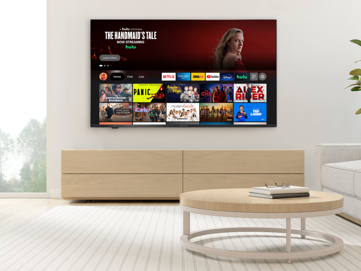 Insignia 50-inch 4K TV on a console in a living room with light brown monochromatic decorating.