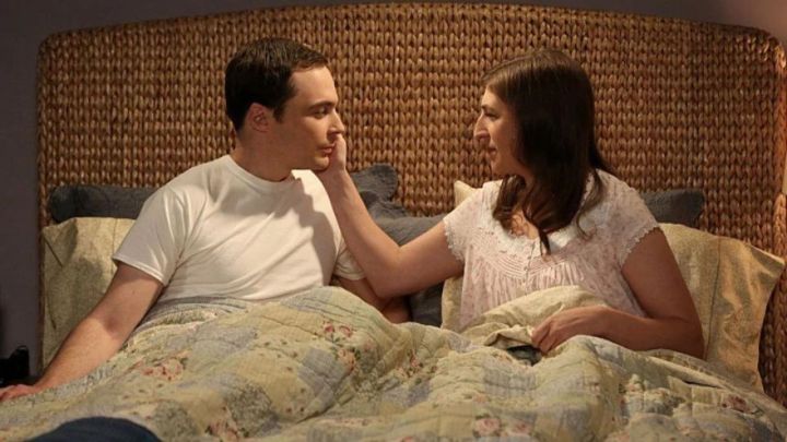 Sheldon e Amy na cama juntos olhando nos olhos um do outro em The Big Bang Theory.