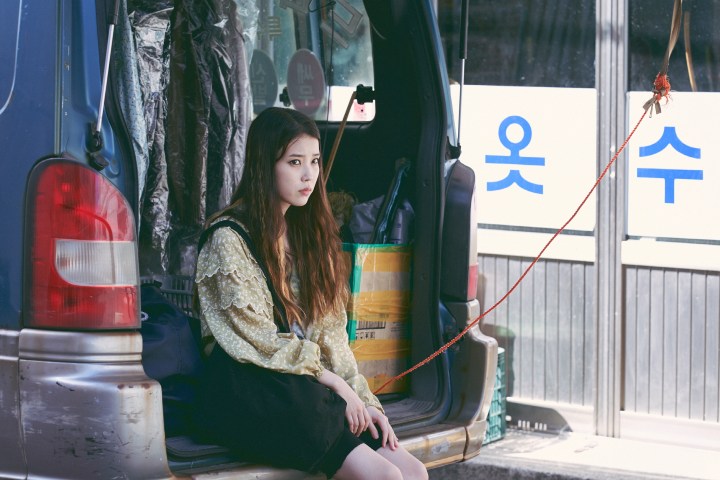 Lee Ji-eun sits in the back of a van in Broker.