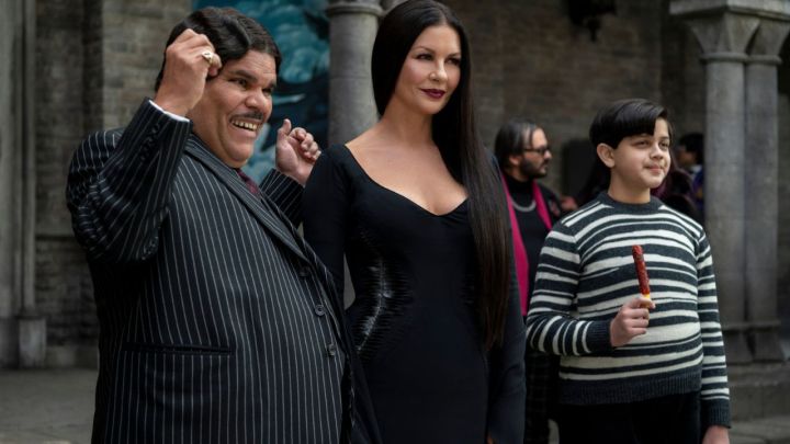 Gomez, Morticia, and Pugsley Addams smiling while standing side by side in Wednesday.
