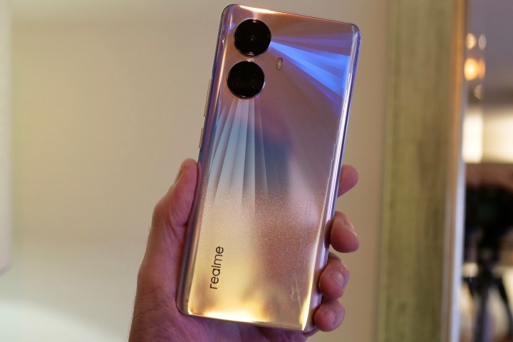 The Realme 10 Pro Plus held in a person's hand.