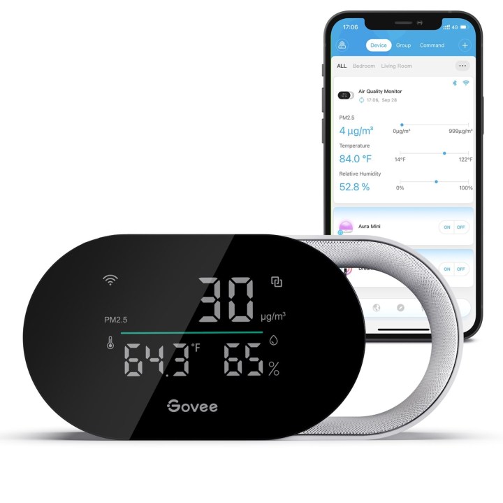 Govee Smart Air Quality Monitor placed in front of a smartphone displaying the Govee app.