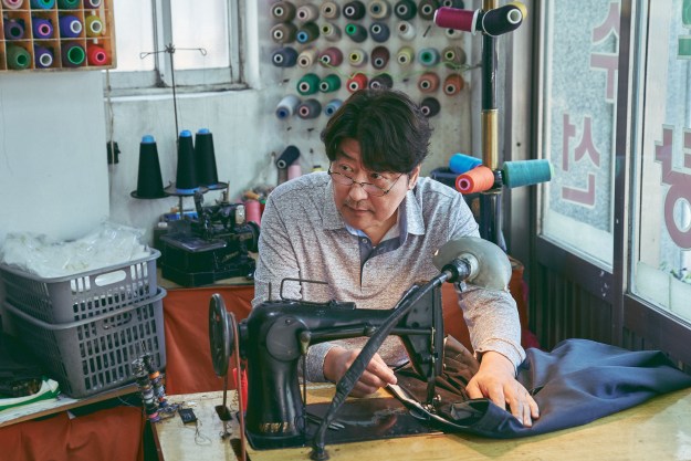 Song Kang-ho operates a sewing machine in Broker.