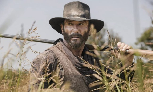 Tim McGraw holds a gun over his shoulder in a scene from 1883.