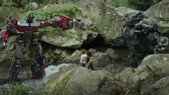 Optimus Prime points a gun at a gorilla in a scene from Transformers Rise of the Beasts.