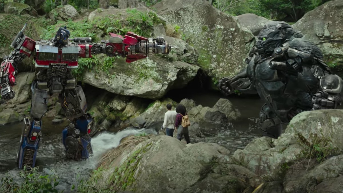 Optimus Prime aponta uma arma para um gorila em uma cena de Transformers Rise of the Beasts.