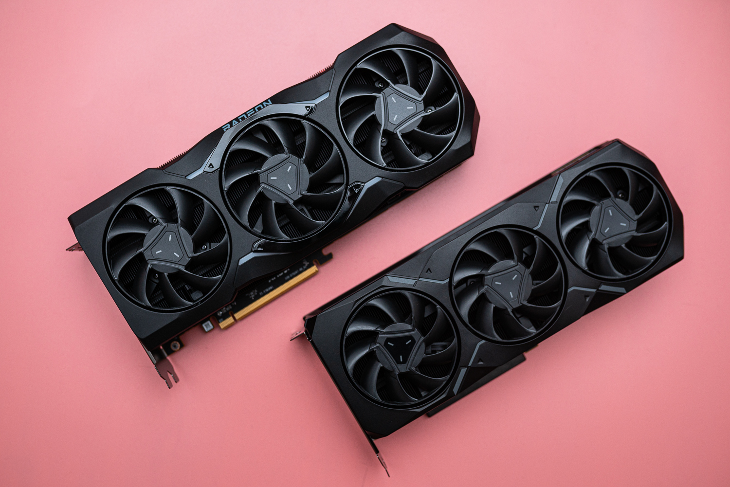 Dos tarjetas gráficas AMD Radeon RX 7000 sobre una superficie rosa.