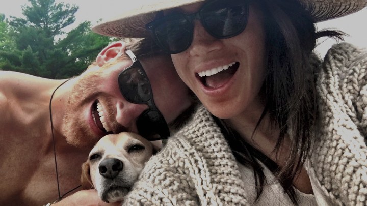 Harry and Meghan posing for a selfie with their dog.