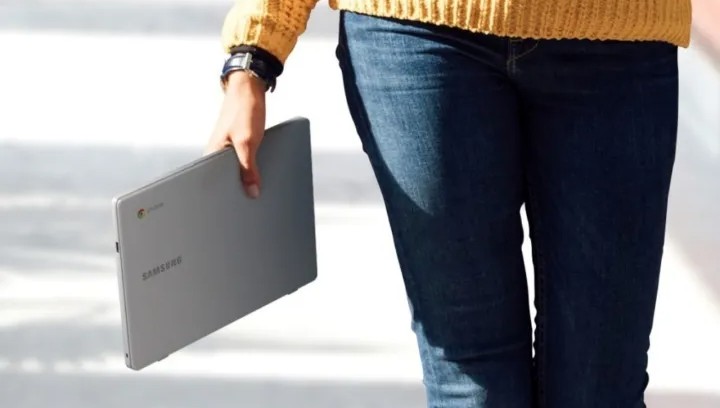 Someone holding a Samsung Chromebook in their hand.
