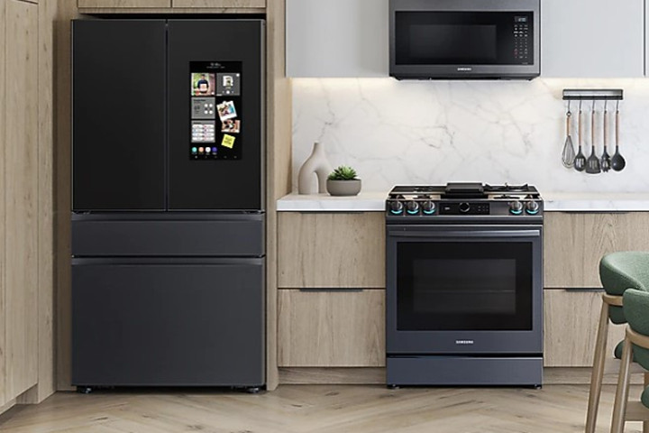 Una cocina con un refrigerador inteligente Samsung Family Hub negro junto a la estufa.
