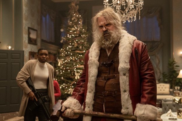 David Harbour dressed as Santa Claus, holding a sledgehammer.