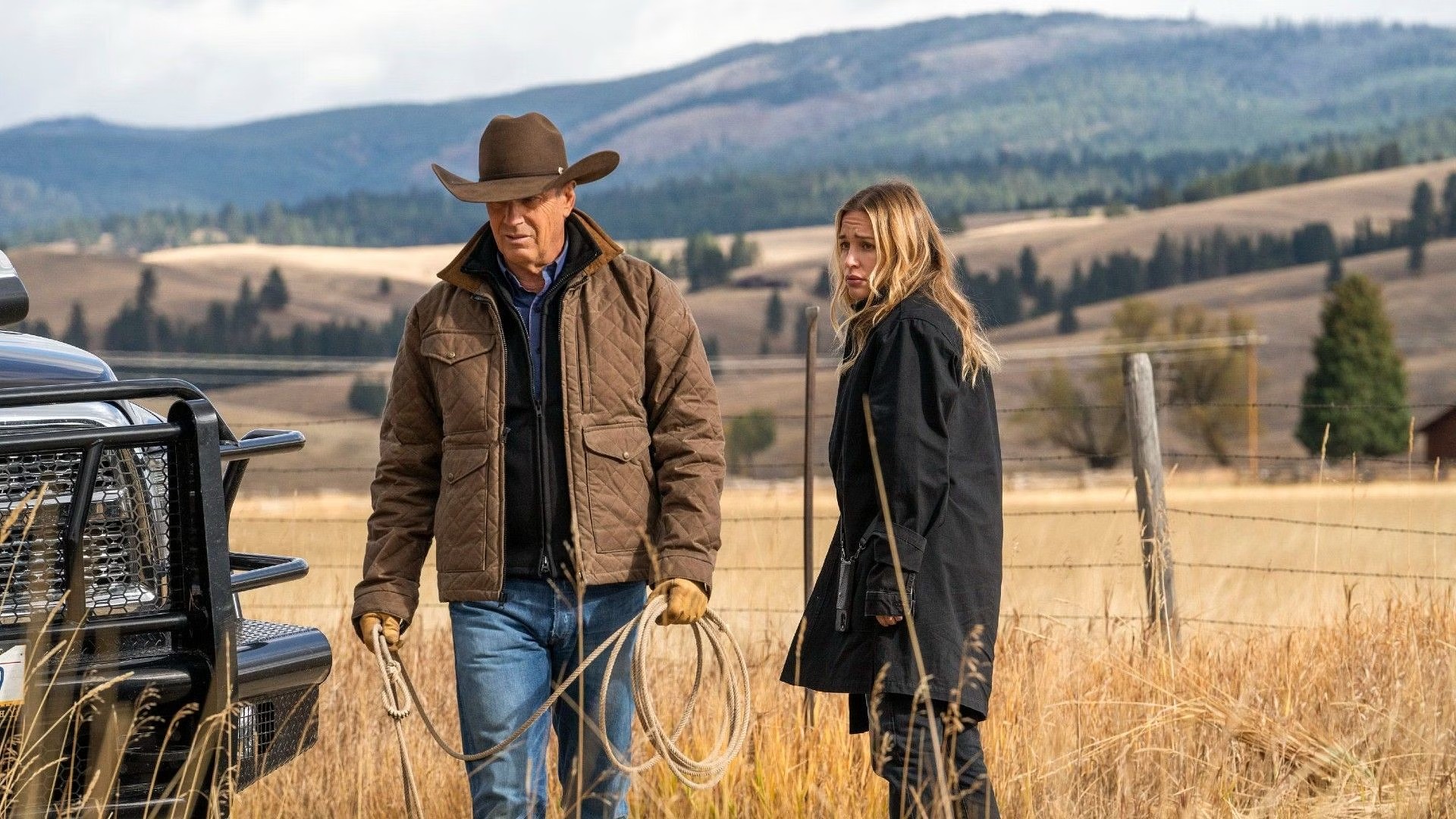 John Dutton and a woman stand in a field in Yellowstone.