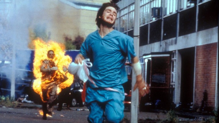 A man runs from a enflamed zombie in 28 Days Later.