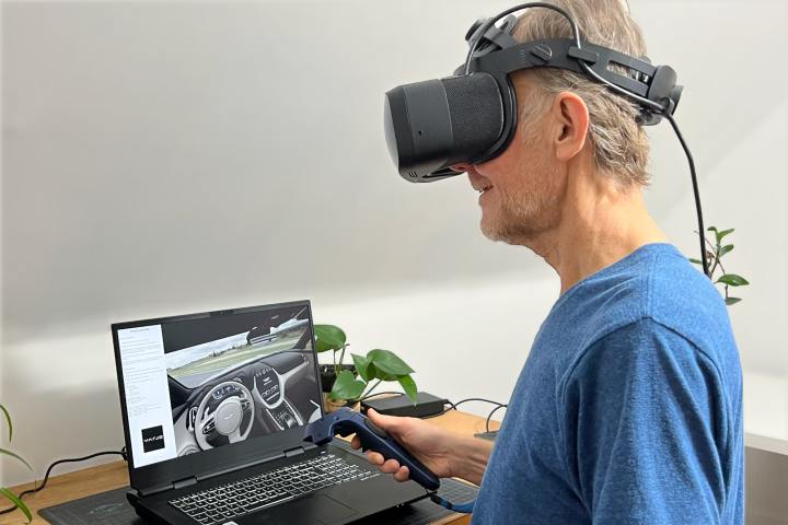 Alan Truly siede davanti a un laptop, indossa il visore Varjo Aero VR.