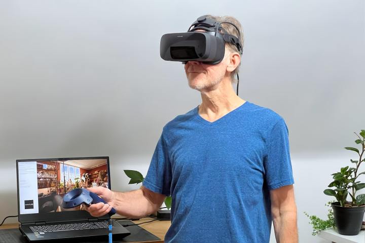 Alan Truly è in piedi davanti a un laptop e indossa il visore Varjo Aero VR