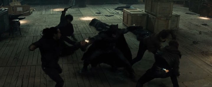 Batman fighting criminals in a warehouse in "Batman v Superman: Dawn of Justice."