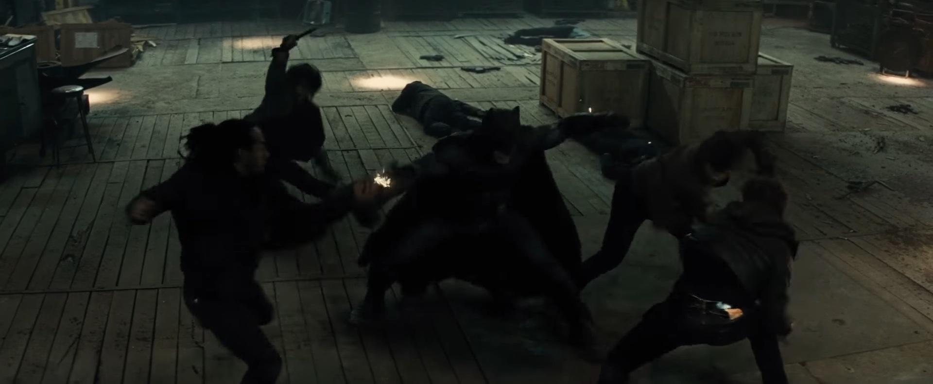 Batman lutando contra criminosos em um armazém em "Batman v Superman: Dawn of Justice".
