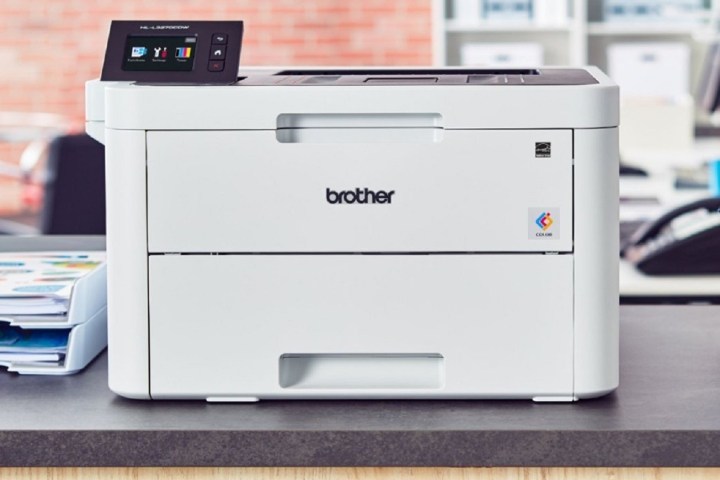 Front view of a Brother laser printer sitting on a counter in an office setting.
