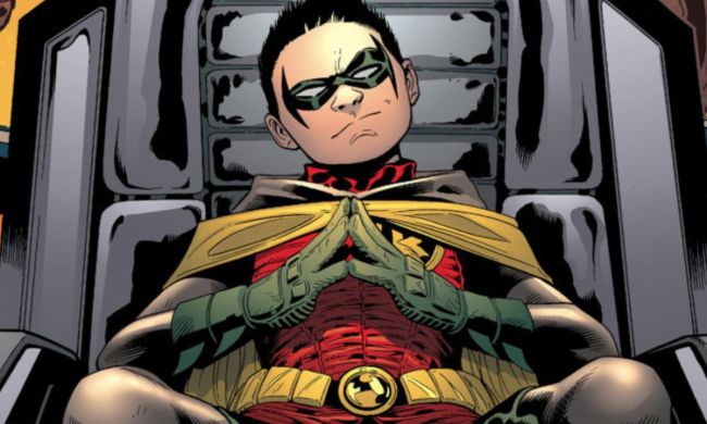 Damian Wayne sitting on a chair and smiling mischievously in DC Comics.