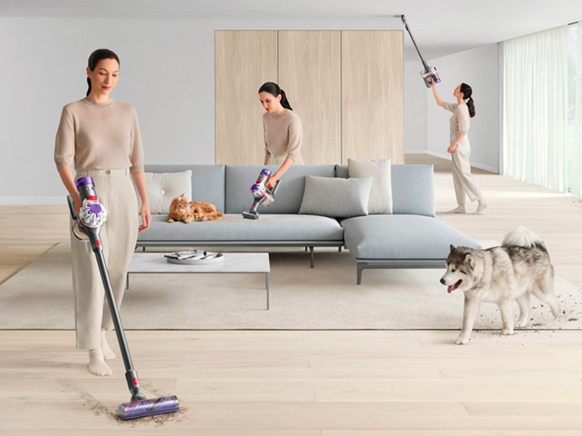 Dyson V8 Cordless Vacuum shown in multiple modes cleaning a house while a dog looks on.