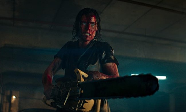 A woman with a bloody face holds a chainsaw in a scene from Evil Dead Rise.