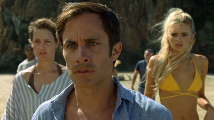 A man and two women looking to the distance with shocked expressions in the movie Old.