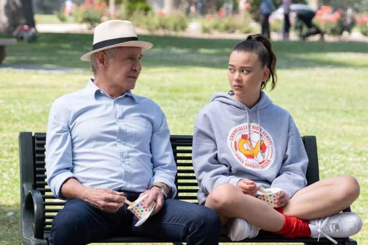 Harrison Ford e Lukita Maxwell sentam-se juntos em um banco de parque em Shrinking.